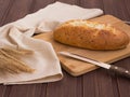 Bread with cheese plank knife and colossus on a wooden background