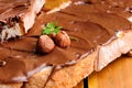 Bread with chocolate cream and hazelnuts on a table closeup Royalty Free Stock Photo