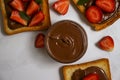 Bread with chocolate paste, brown  closeup  strawberries on a light background Royalty Free Stock Photo