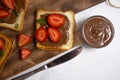 Bread with chocolate paste, dessert spread strawberries on a light background Royalty Free Stock Photo