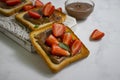 Bread with chocolate paste, cream morning strawberries on a light background Royalty Free Stock Photo