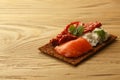 Bread crisp with salmon, soft cheese, dried tomatoes and chervil