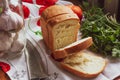 Bread with cut pieces on a napkin, knife, tomatoes, herbs and garlic Royalty Free Stock Photo