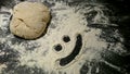 Bread dough with a smiley face in flour. Royalty Free Stock Photo