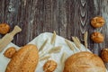 Bread with flax seeds, buns or cakes, ears of wheat on a brown wooden background, home baking Royalty Free Stock Photo