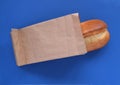 French roll in a paper bag on a blue background