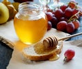 Bread with honey on paper, ripe grapes, nuts and apples on a dark background Royalty Free Stock Photo