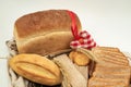 Bread loaf with multiple sliced pieces placed on rustic fabric with wheat grains creating a natural warm bakery themed composition Royalty Free Stock Photo