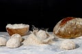 A bread loaf splash on a pile of wholewheat flour on marble countertop with dark background