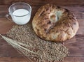 Bread, milk and wheat on a wooden background