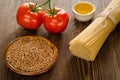 Bread with pasta, tomatos, oil and buckwheat on wood