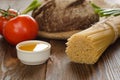 Bread with pasta, tomatos, onion, oil and pepper on wood