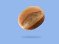 Freshly baked bread roll floating against a blue background showcasing the soft texture and golden crust Royalty Free Stock Photo