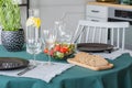 Bread, salad, plate and wine glasses on table covered with emerald green tablecloth