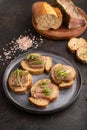 Bread sandwiches with jerky salted meat, sorrel and cilantro microgreen on black. side view