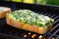 bread slice with dripping garlic herb butter on a hot grilling pan