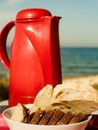 Bread slices and thermos on beach