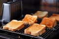 bread slices toasting in different toasters