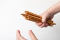 bread sticks in child hand on white background, crispy snack with poppy seeds