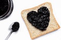 Bread with sweet blackberry jam in shape of heart on white background. Royalty Free Stock Photo