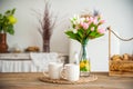 Bread in a textured wooden box in the kitchen in a rustic style. Breakfast, bread, white cups in the interior of bright Scandinavi