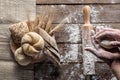 Bread with wheat ears and flour on wood board, top view