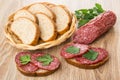 Bread in wicker basket, sandwiches with smoked sausage and parsley