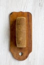 Bread on wooden cutting board on white woodem background. Royalty Free Stock Photo