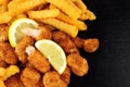 Breadcrumb Covered Fried Scampi And Chips On Slate Background