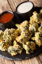 Breaded broccoli baked with parmesan served with sauces. vertical