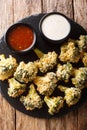 Breaded broccoli baked with parmesan served with sauces. Vertical top view