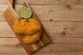 Breaded chicken filet with lemon slices, on a wooden background. top wiew