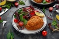 Breaded Chicken Kiev breast stuffed with butter, garlic and herbs served with vegetables in a plate. Royalty Free Stock Photo