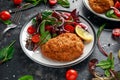 Breaded Chicken Kiev breast stuffed with butter, garlic and herbs served with vegetables in a plate. Royalty Free Stock Photo