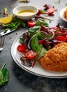 Breaded Chicken Kiev breast stuffed with butter, garlic and herbs served with vegetables in a plate. Royalty Free Stock Photo