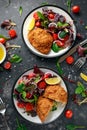 Breaded Chicken Kiev breast stuffed with butter, garlic and herbs served with vegetables in a plate. Royalty Free Stock Photo