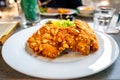 Breaded chicken steak with almonds on white plate on restaurant table Royalty Free Stock Photo