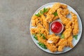Breaded chicken strips with tomato ketchup on a white plate. Fast food on dark brown background. Top view with copy space Royalty Free Stock Photo