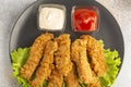 Breaded chicken strips with two kinds of sauces on gray plate. Fast food on gray stone. Flat lay. closeup Royalty Free Stock Photo