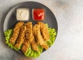 Breaded chicken strips with two kinds of sauces on gray plate. Fast food on gray stone. Flat lay. With copy space. Royalty Free Stock Photo