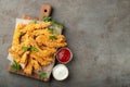 Breaded chicken strips with two kinds of sauces on a wooden Board. Fast food on dark brown background. Top view with copy space