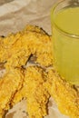 Breaded chicken wings and a glass of lemonade on a grey paper background. Close up Royalty Free Stock Photo