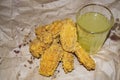 Breaded chicken wings and a glass of lemonade on a grey paper background. Close up Royalty Free Stock Photo