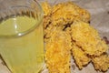 Breaded chicken wings and a glass of lemonade on a grey paper background. Close up Royalty Free Stock Photo