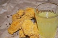 Breaded chicken wings and a glass of lemonade on a grey paper background. Close up Royalty Free Stock Photo