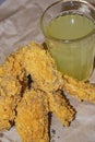 Breaded chicken wings and a glass of lemonade on a grey paper background. Close up Royalty Free Stock Photo