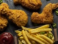 Breaded crispy fried chicken legs, wings, french fries and sauce Royalty Free Stock Photo