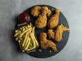 Breaded crispy fried chicken legs, wings, french fries and sauce Royalty Free Stock Photo