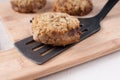 Breaded cutlet on spatula and two more patties Royalty Free Stock Photo
