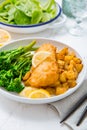 Breaded fisch fillet with spicy baked potatoes and broccoli bimi salad